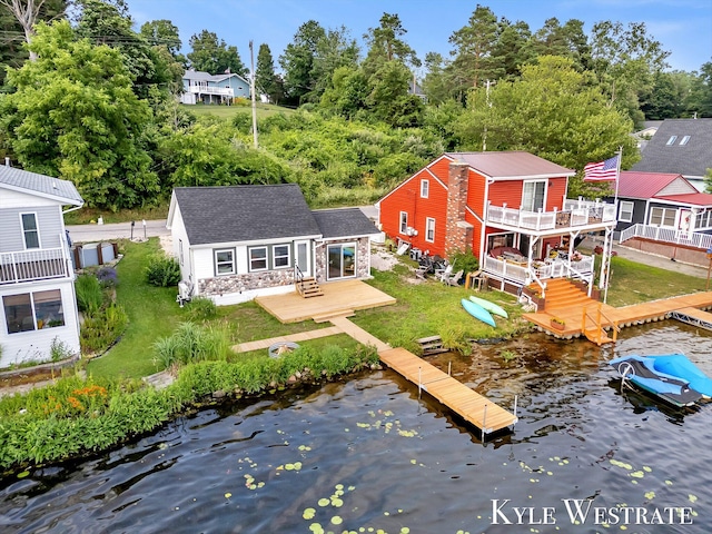 12230 Mac Dr NE, Belding, MI 48809 - back of house featuring a lawn, an outdoor structure, a deck with water view, and stone siding