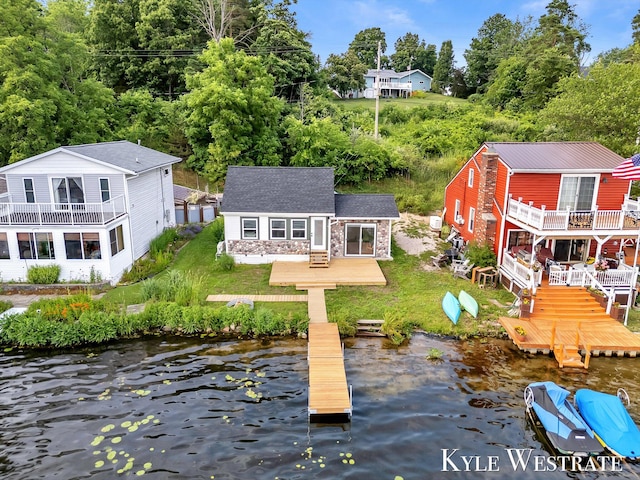 12230 Mac Dr NE, Belding, MI 48809 - back of house with an outdoor structure, stone siding, a lawn, and a deck with water view