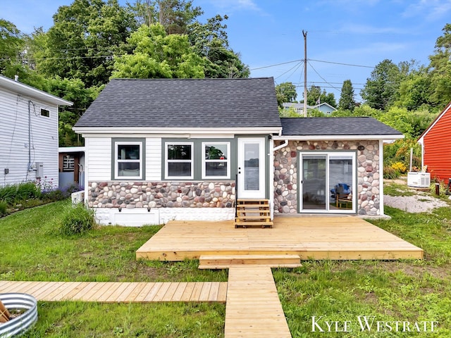 12230 Mac Dr NE, Belding, MI 48809 - back of property featuring stone siding, a wooden deck, and a shingled roof