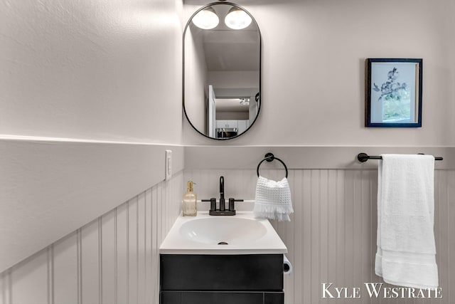 12230 Mac Dr NE, Belding, MI 48809 - bathroom with vanity, a decorative wall, and wainscoting