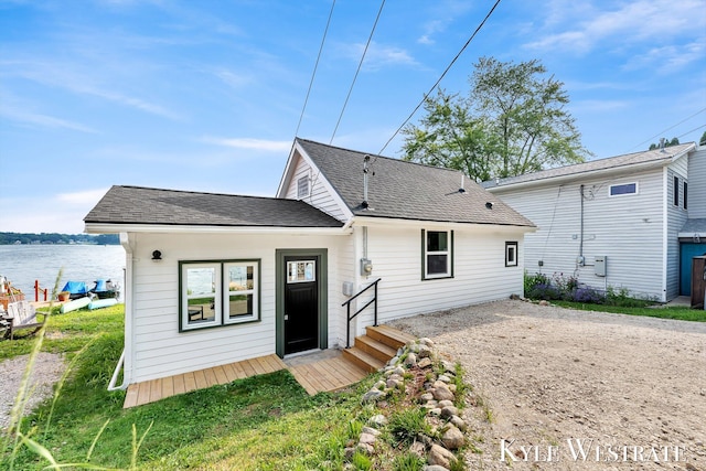 12230 Mac Dr NE, Belding, MI 48809 - rear view of property featuring dirt driveway, roof with shingles, and a water view