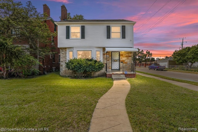 17617 Kentucky St, Detroit, MI 48221 - view of front of home with stone siding, a front lawn, a chimney, and covered porch