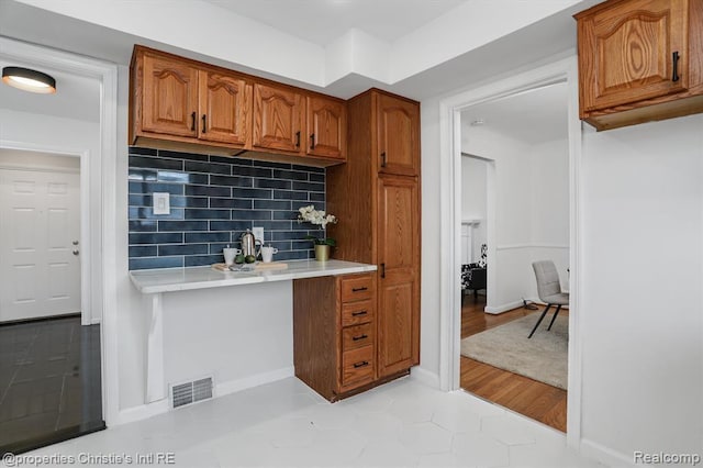 17617 Kentucky St, Detroit, MI 48221 - kitchen with light countertops, brown cabinets, backsplash, and light tile patterned flooring