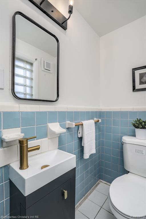 17617 Kentucky St, Detroit, MI 48221 - half bath with vanity, tile walls, tile patterned flooring, and a wainscoted wall