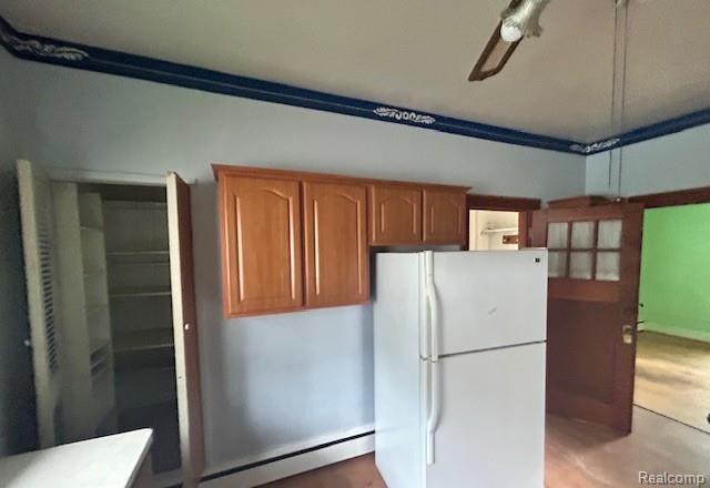 2170 Avondale St, Sylvan Lake, MI 48320 - kitchen featuring freestanding refrigerator, a baseboard heating unit, brown cabinets, ceiling fan, and light countertops