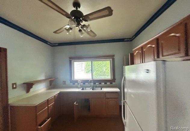 2170 Avondale St, Sylvan Lake, MI 48320 - kitchen featuring freestanding refrigerator, ceiling fan, light countertops, and brown cabinetry