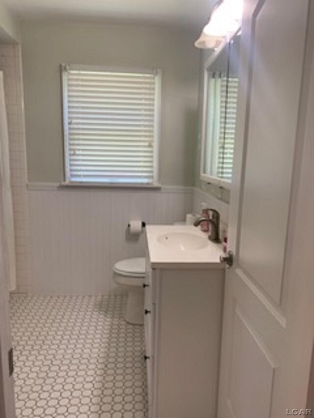 609 Orchard Ln, Tecumseh, MI 49286 - bathroom with vanity, wainscoting, curtained shower, plenty of natural light, and tile patterned flooring