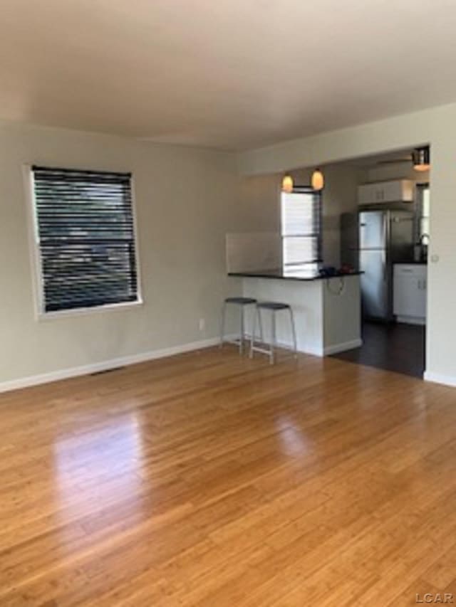 609 Orchard Ln, Tecumseh, MI 49286 - unfurnished living room with wood finished floors and baseboards