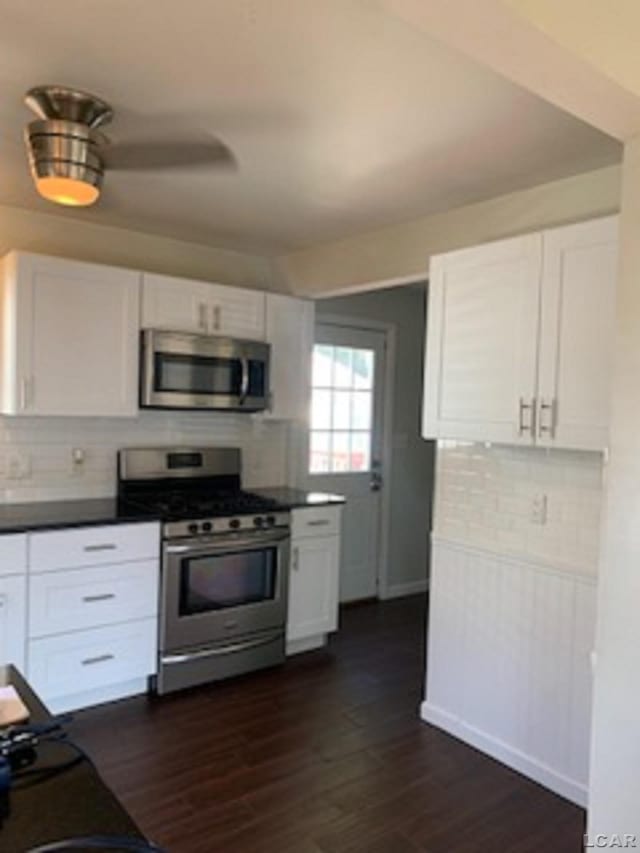 609 Orchard Ln, Tecumseh, MI 49286 - kitchen with appliances with stainless steel finishes, white cabinets, tasteful backsplash, dark wood-type flooring, and dark countertops