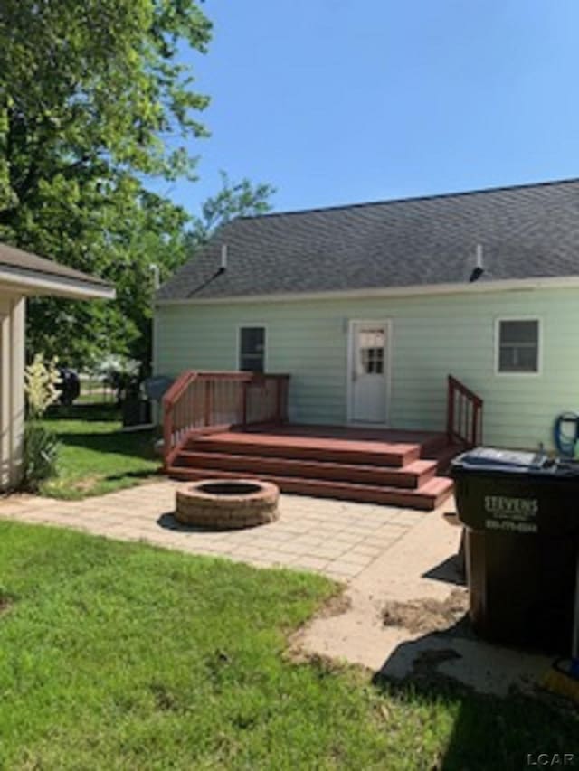 609 Orchard Ln, Tecumseh, MI 49286 - rear view of house with an outdoor fire pit, a wooden deck, a yard, and a patio
