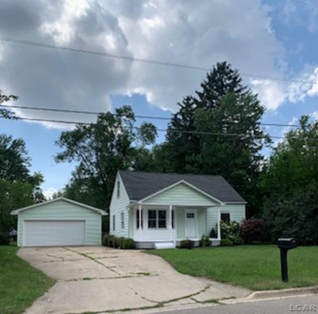 609 Orchard Ln, Tecumseh, MI 49286 - single story home with a garage, an outbuilding, a front yard, and a porch