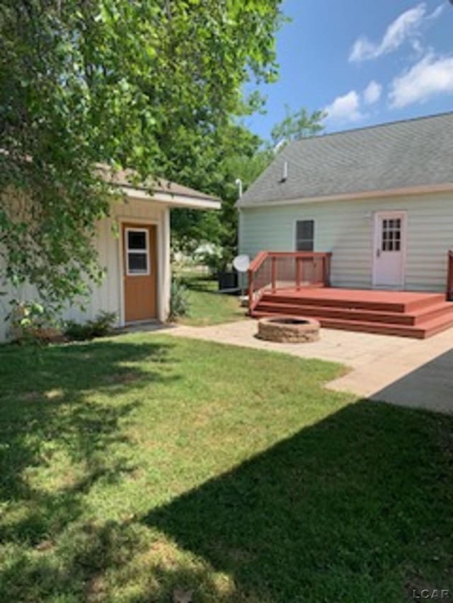 609 Orchard Ln, Tecumseh, MI 49286 - view of green lawn featuring a deck, a patio area, and a storage unit