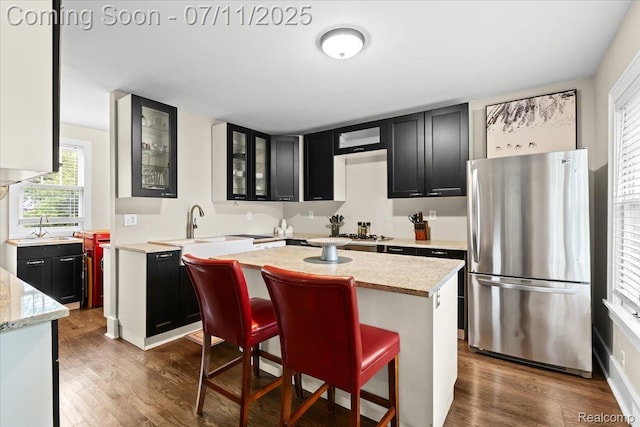 342 King St, Highland, MI 48357 - kitchen featuring freestanding refrigerator, dark cabinetry, and wood finished floors