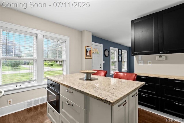 342 King St, Highland, MI 48357 - kitchen featuring dark cabinetry, oven, a center island, and dark wood-type flooring