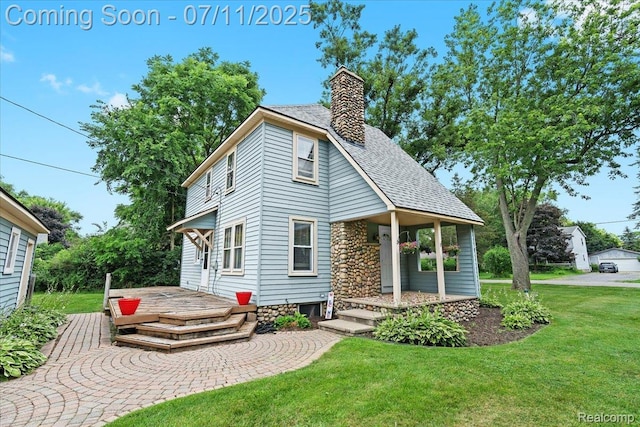 342 King St, Highland, MI 48357 - view of front of home featuring a front yard, a chimney, roof with shingles, and a deck