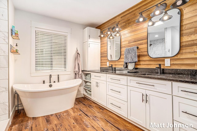2771 Deer Run Rd, Muskegon, MI 49445 - bathroom featuring double vanity, a freestanding tub, wood finished floors, and wood walls