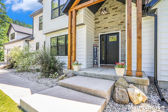 2771 Deer Run Rd, Muskegon, MI 49445 - view of exterior entry with covered porch, board and batten siding, and stone siding
