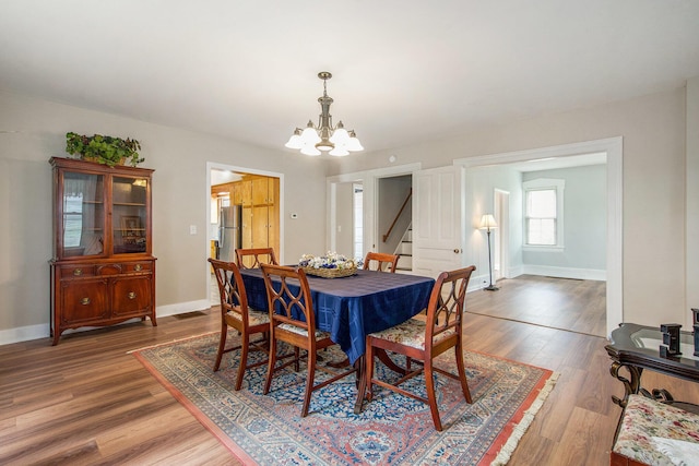 9148 Austin Rd, Saline, MI 48176 - dining area featuring a chandelier, wood finished floors, and stairs