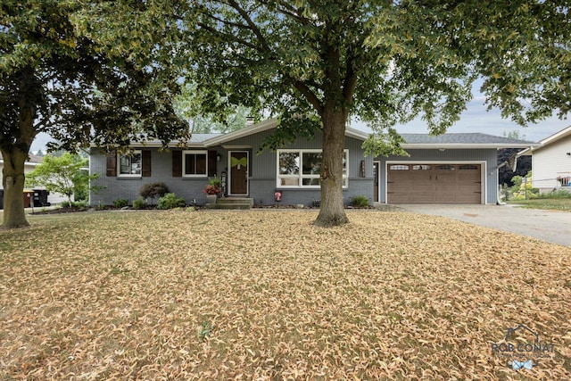 2641 Garfield Ave NW, Grand Rapids, MI 49544 - ranch-style house featuring asphalt driveway, a garage, brick siding, and a front yard