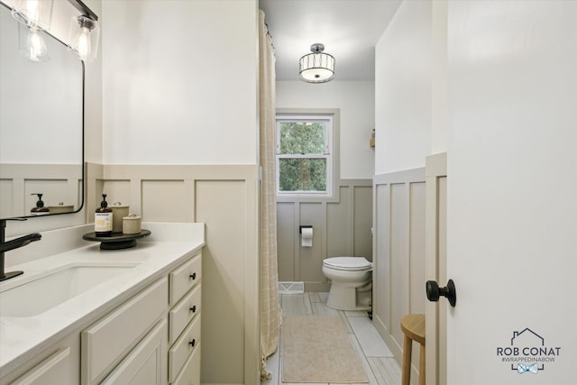 2641 Garfield Ave NW, Grand Rapids, MI 49544 - full bath with a decorative wall, wainscoting, vanity, and a shower with curtain
