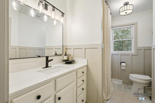 2641 Garfield Ave NW, Grand Rapids, MI 49544 - bathroom with a decorative wall, wainscoting, vanity, and a shower with curtain
