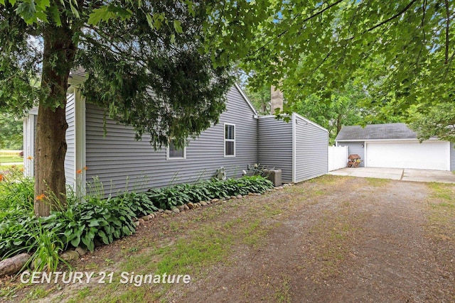 6357 Mackinaw Rd, Saginaw, MI 48604 - view of property exterior featuring an outbuilding, a detached garage, driveway, and a chimney