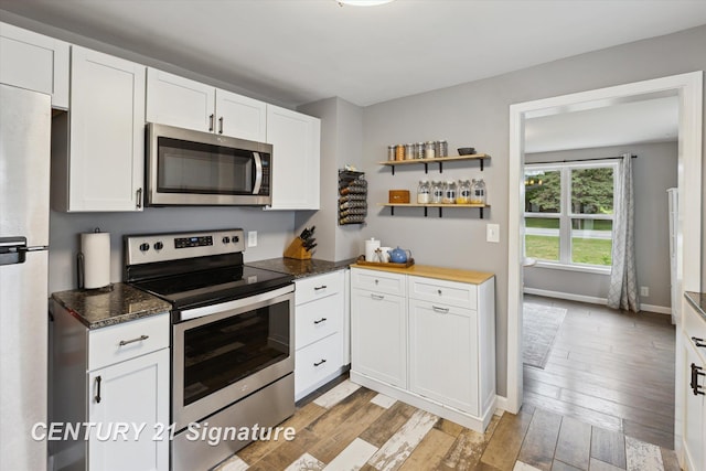 6357 Mackinaw Rd, Saginaw, MI 48604 - kitchen featuring appliances with stainless steel finishes, white cabinetry, light wood-type flooring, open shelves, and dark stone countertops