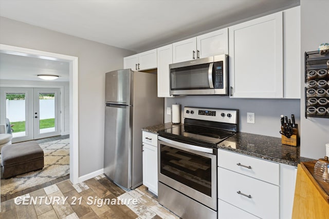 6357 Mackinaw Rd, Saginaw, MI 48604 - kitchen with appliances with stainless steel finishes, white cabinets, french doors, and dark stone countertops