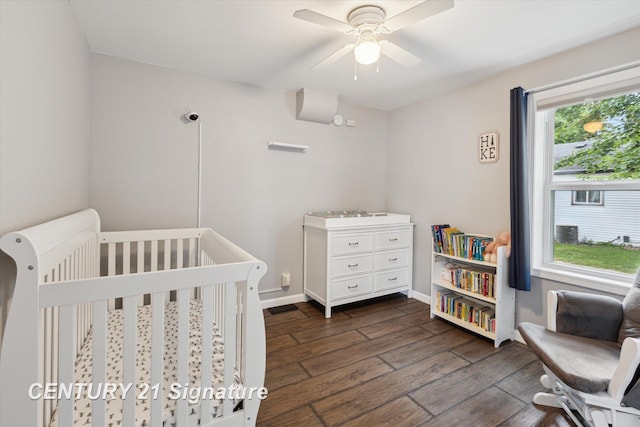 6357 Mackinaw Rd, Saginaw, MI 48604 - bedroom with dark wood finished floors, a crib, and ceiling fan