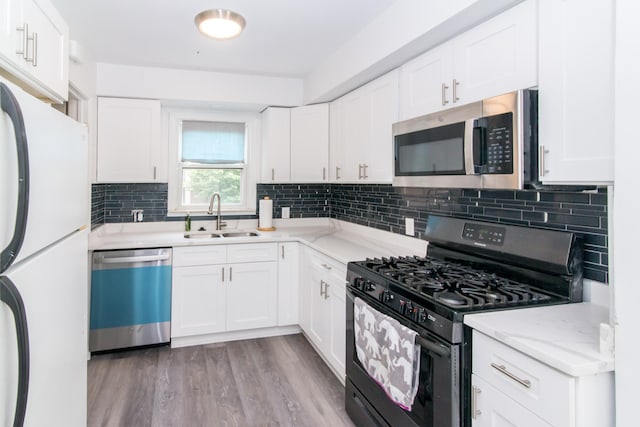 11015 Fairfield St, Livonia, MI 48150 - kitchen featuring appliances with stainless steel finishes, backsplash, white cabinets, and light stone counters