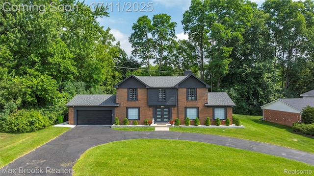 5534 Apple Ridge Trl, West Bloomfield, MI 48322 - view of front of house with brick siding, asphalt driveway, a front yard, a garage, and a shingled roof