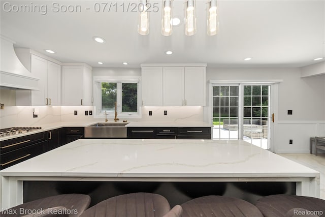 5534 Apple Ridge Trl, West Bloomfield, MI 48322 - kitchen featuring premium range hood, stainless steel gas stovetop, decorative backsplash, light stone countertops, and recessed lighting