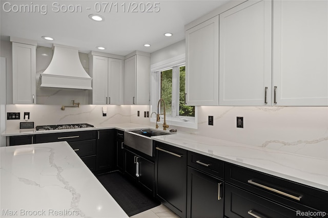 5534 Apple Ridge Trl, West Bloomfield, MI 48322 - kitchen with premium range hood, dark cabinets, white cabinetry, stainless steel gas cooktop, and recessed lighting