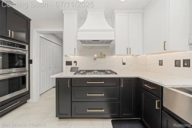 5534 Apple Ridge Trl, West Bloomfield, MI 48322 - kitchen featuring appliances with stainless steel finishes, custom exhaust hood, white cabinets, light stone countertops, and dark cabinets