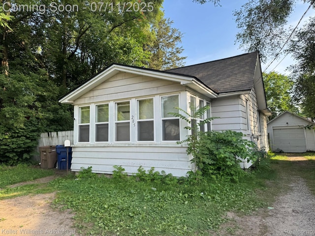 285 Voorheis St, Pontiac, MI 48341 - bungalow with a shingled roof, dirt driveway, an outbuilding, and a detached garage