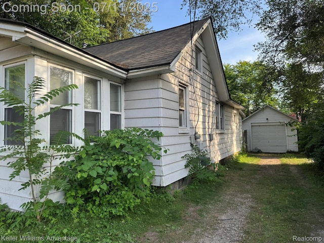 285 Voorheis St, Pontiac, MI 48341 - view of home's exterior featuring a shingled roof, an outbuilding, driveway, and a garage