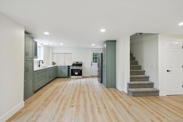 11240 Silver Lake Rd, Byron, MI 48418 - kitchen featuring appliances with stainless steel finishes, green cabinets, light wood-style flooring, light countertops, and recessed lighting