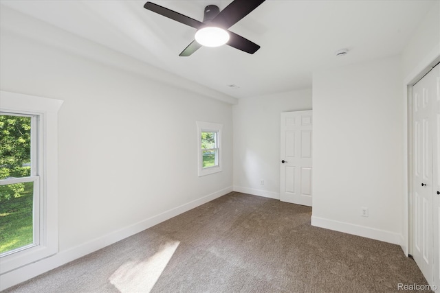 11240 Silver Lake Rd, Byron, MI 48418 - unfurnished bedroom with multiple windows, carpet flooring, a closet, and a ceiling fan