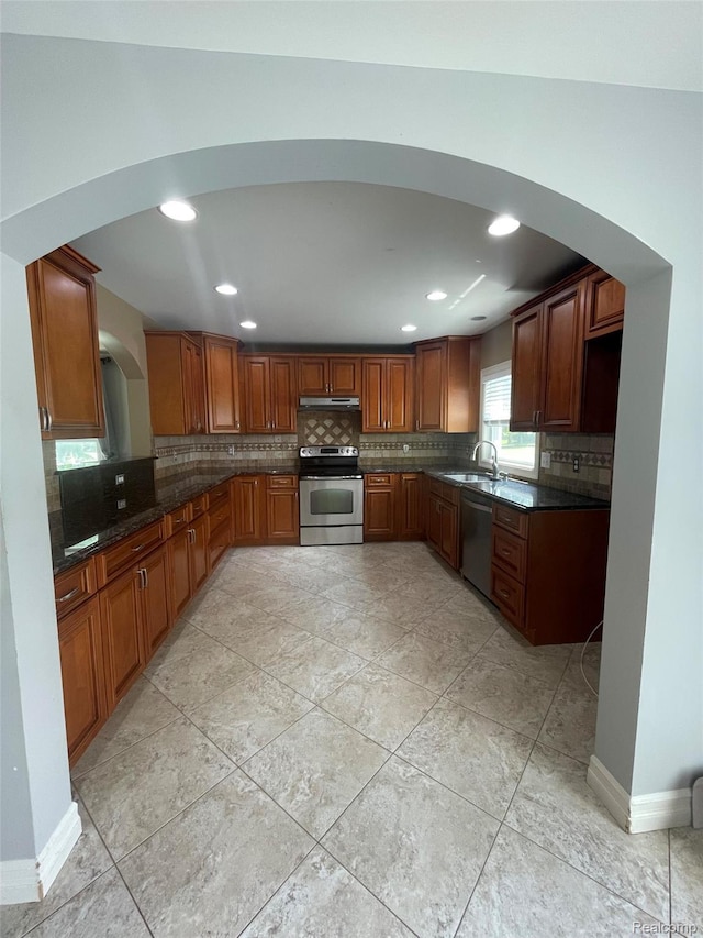 23364 Clark Rd, Belleville, MI 48111 - kitchen with stainless steel appliances, under cabinet range hood, decorative backsplash, recessed lighting, and brown cabinetry