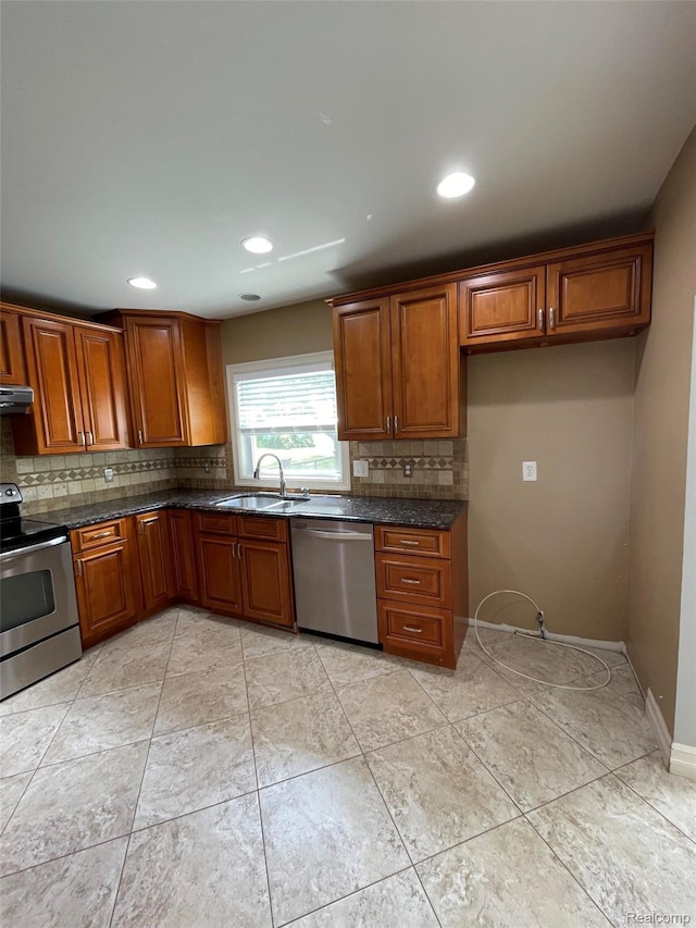 23364 Clark Rd, Belleville, MI 48111 - kitchen featuring stainless steel appliances, brown cabinetry, decorative backsplash, recessed lighting, and dark stone countertops