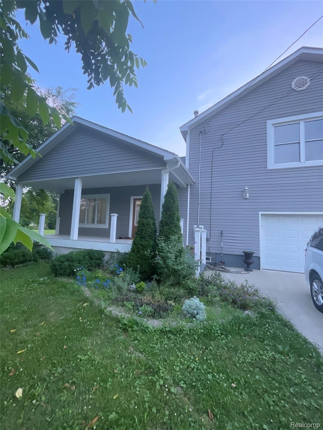 23364 Clark Rd, Belleville, MI 48111 - view of property exterior with covered porch, a garage, driveway, and a yard
