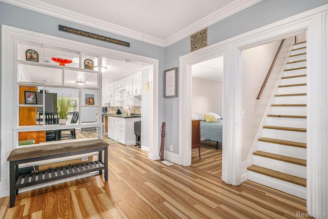 124 N Line St, Chesaning, MI 48616 - hall with light wood-style flooring, stairs, and crown molding