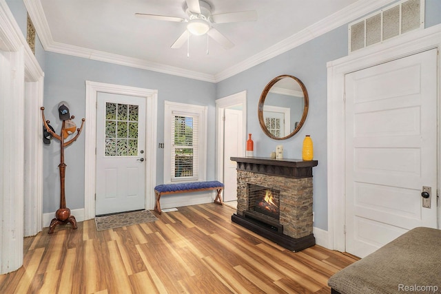 124 N Line St, Chesaning, MI 48616 - foyer with light wood-style flooring, a ceiling fan, crown molding, and a stone fireplace