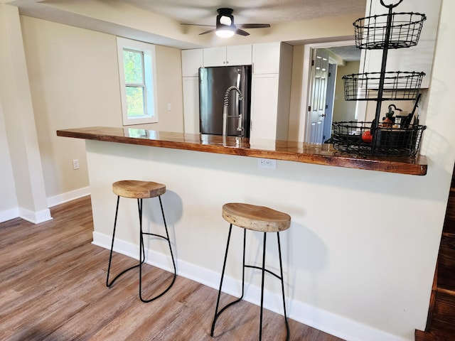 5743 107th Ave, Pullman, MI 49450 - kitchen featuring freestanding refrigerator, a breakfast bar area, a ceiling fan, and white cabinetry