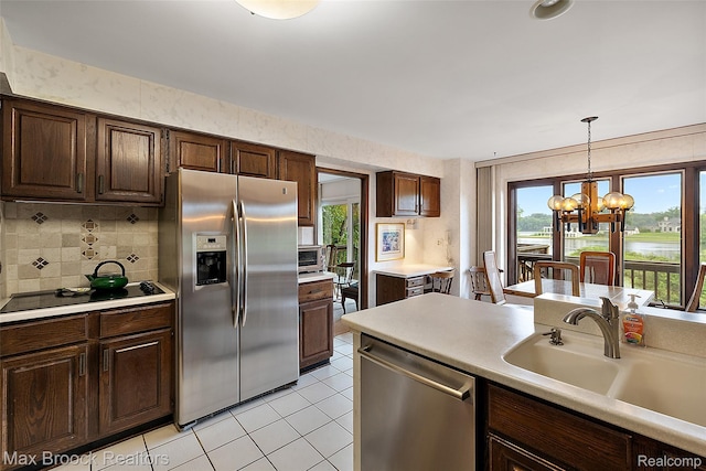 3350 Franklin Rd, Bloomfield Hills, MI 48302 - kitchen featuring stainless steel appliances, light countertops, a chandelier, decorative backsplash, and pendant lighting
