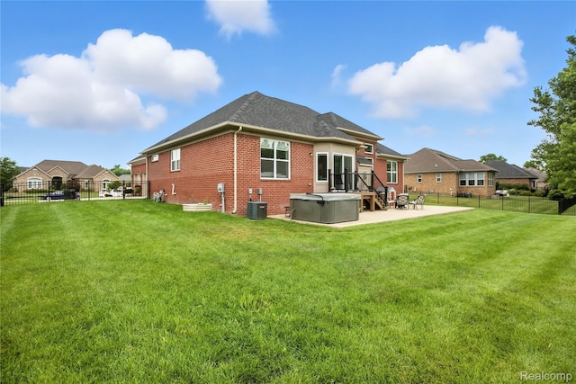 27245 Ritter Blvd, Flat Rock, MI 48134 - back of property featuring a hot tub, brick siding, a fenced backyard, a patio area, and a shingled roof