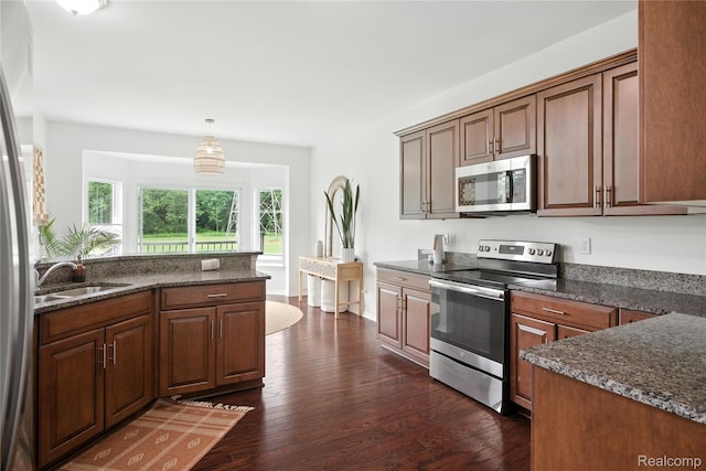 27245 Ritter Blvd, Flat Rock, MI 48134 - kitchen with stainless steel appliances, dark wood finished floors, pendant lighting, and dark stone countertops