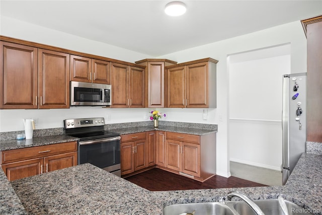 27245 Ritter Blvd, Flat Rock, MI 48134 - kitchen featuring appliances with stainless steel finishes, stone counters, brown cabinets, and dark wood-style floors