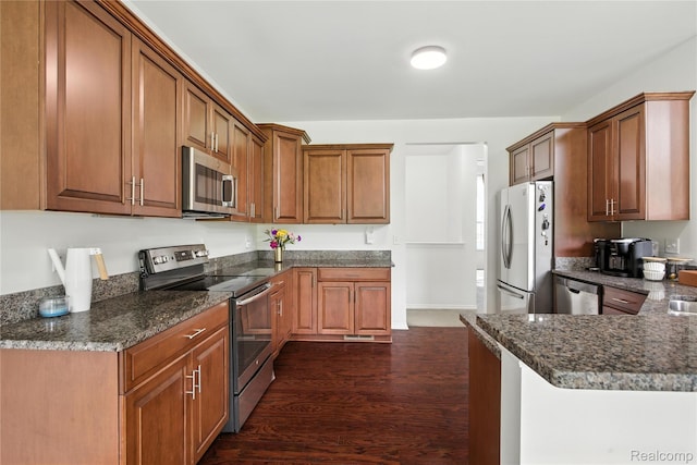 27245 Ritter Blvd, Flat Rock, MI 48134 - kitchen featuring stainless steel appliances, dark wood-style floors, brown cabinets, and dark stone countertops