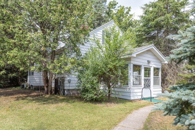 425 6th St, Baldwin, MI 49304 - obstructed view of property with a sunroom and a front lawn